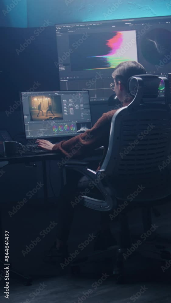 Poster female film editor or colorist does color grading on computer in modern studio. big monitors with rg