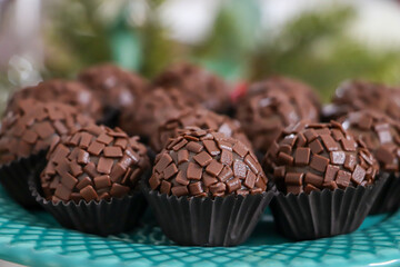several gourmet chocolate brigadeiros in a green pot
