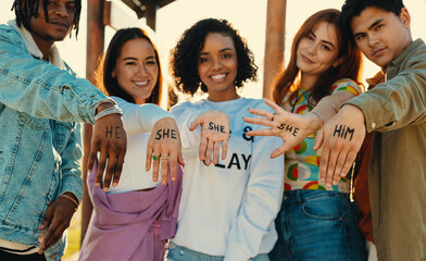 Gen Z friends displaying gender pronouns he, she, and him together outdoors