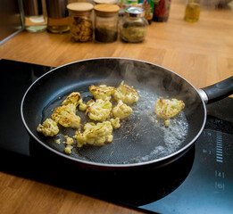 Chef at the kitchen preparing bean porridge with cauliflower and vegetables