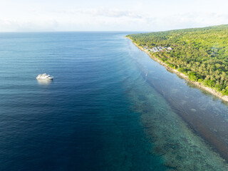 Calm water bathes the scenic coast of a remote island in the Forgotten Islands of eastern Indonesia. This beautiful region harbors extraordinary marine biodiversity.