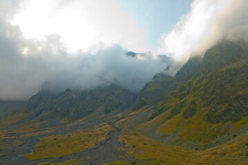 sharp mountain peaks surrounded by wisps of cloud on the summits