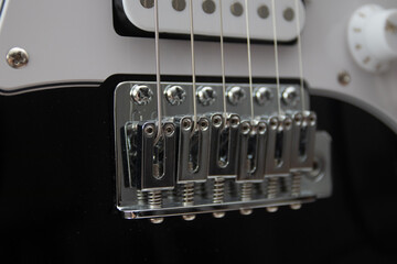 close up of a black electric guitar bridge