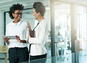 Business women, tablet and talking or planning in office for communication, collaboration and progress report. People, notebook or tech meeting together in workplace for teamwork and partnership