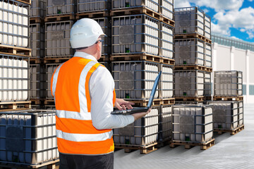 Man is industrialist. Logistician with laptop with his back to camera. Tanks for transporting...