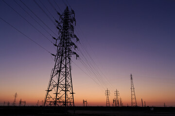 Fototapeta premium 夜明け前の空と鉄塔と送電線の風景