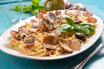 Vassoio di spaghetti conditi con vongole veraci, pasta italiana, cucina mediterranea 