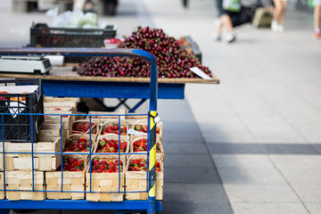 Strawberries and cherries. Selling and buying on the street in Poland on a sunny day. Visible prices