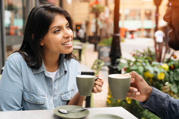 Woman and Man Enjoying Coffee Together at Outdoor Cafe