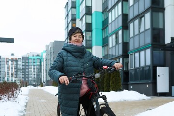 Healthy pensioner woman leads a healthy lifestyle and rides a bike in winter