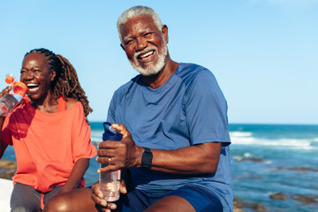 Mature African American couple laughing by the coastal water