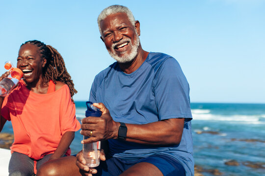 Mature African American couple laughing by the coastal water