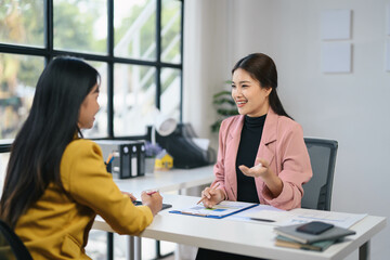 Professional Business Meeting Between Two Women in Modern Office Setting with Natural Light and Contemporary Design Elements