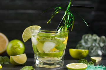 citrus lemon drink with lime in a glass with a straw, mint and ice. Refreshing drink, freshly squeezed refreshing juice
