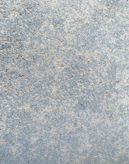 A white wall with a hole in it. The wall is cracked and has a rough texture