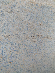 A white wall with a hole in it. The wall is cracked and has a rough texture