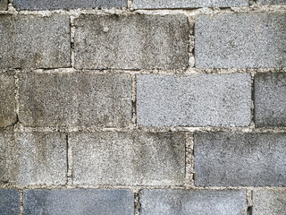 A white wall with a hole in it. The wall is cracked and has a rough texture