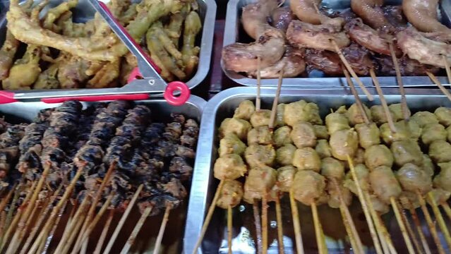 Angkringan food, Indonesian street food containing a variety of foods such as snail satay, intestine satay, quail egg satay, chicken feet