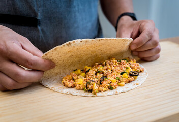 Chef at the kitchen preparing quesadillas with tofu and sweet corn