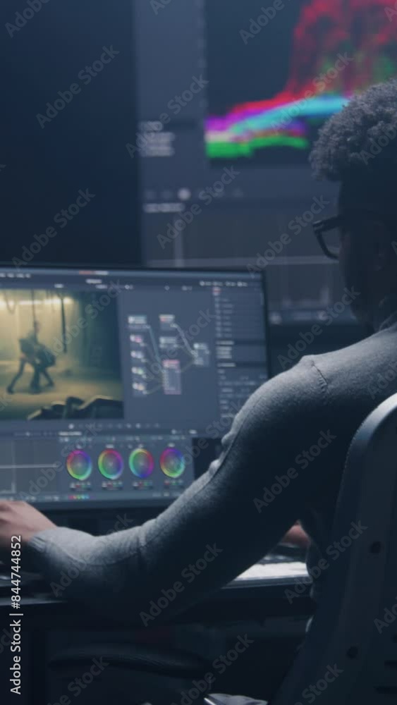 Poster african american film editor does color grading on computer in modern studio. big monitors with rgb 
