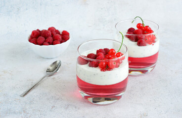a glass of yogurt with raspberries and cream cheese and jelly