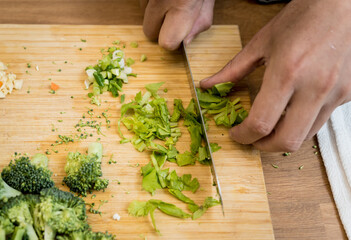 Chef at the kitchen preparing lentils soup with cauliflower and broccoli