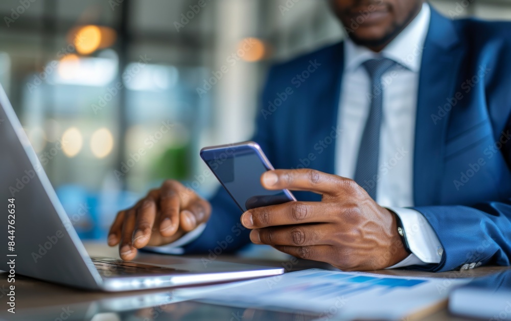 Poster a man in a suit is using a cell phone while sitting at a desk. concept of professionalism and focus,