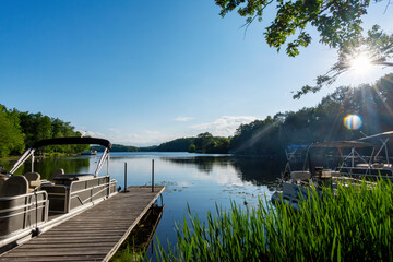 Looking out onto a Wisconsin lake in the late afternoon on a calm day from the shore with a ...