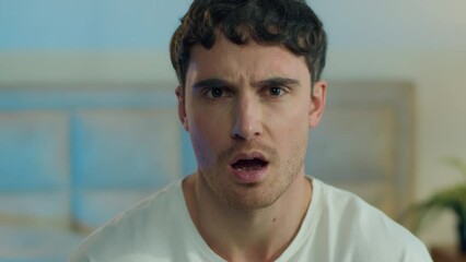 Close up face young Caucasian European man disgust misunderstanding rejection squint frowning confused reaction displeased portrait expression negative frustrated gesture feeling home bedroom indoors