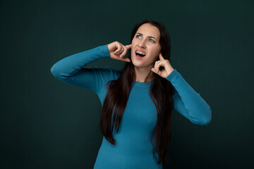 Woman in Blue Shirt Holding Hands to Ears