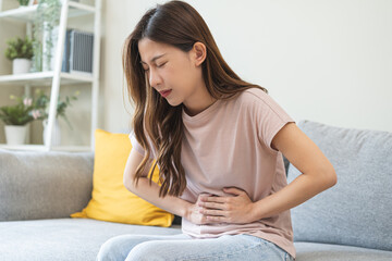 Flatulence asian young woman intolerance hand in stomach ache, suffer from food poisoning,...
