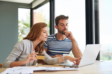 Laptop, couple and credit card at table in morning for online shopping with purchase in house on...