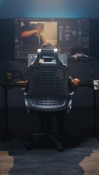 The editor works in studio on computer, edits video, makes color correction for movie post production. Big screens showing color grading program interface with film footage, RGB graphic and levels.