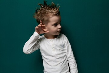Little Boy With Mohawk Standing in Front of Green Wall