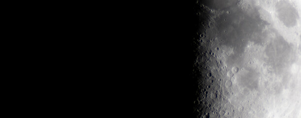 Half moon during the first quarter phase isolated against a black sky.
