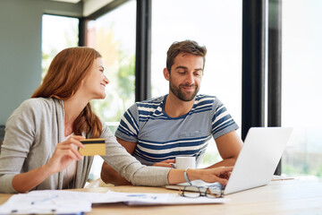 Couple, laptop and credit card at table in morning for online shopping with purchase in house on...