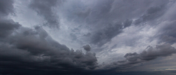 Fototapeta premium Bad or moody weather sky and environment. carbon dioxide emissions, greenhouse effect, global warming, climate change. The dark sky with heavy clouds converging and a violent storm before the rain.
