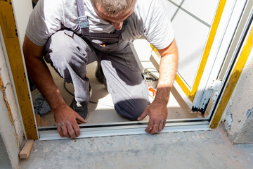 Professional carpenters installing an entrance door in a new apartment. Door installation worker...