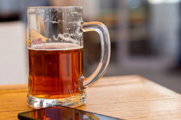 Glass cup with beer on a wooden table