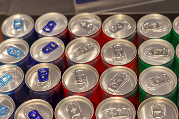 
Colorful metal cans of beer are arranged on a shelf in symmetrical rows