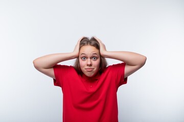 Funny girl with brown hair laughs loudly and holds her head