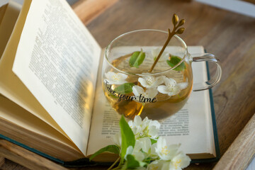 A cup of aromatic tea with a book and jasmine flowers and a cake with blackberries, summer mood.