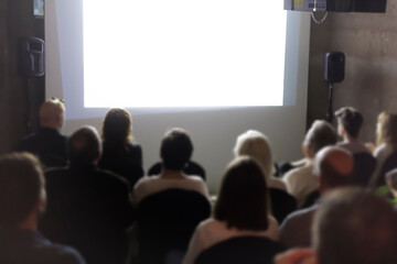 Audience members watching a presentation in a conference room