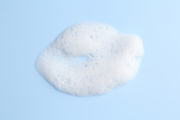 Sample of fluffy foam on light blue background, top view
