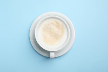 Aromatic coffee in cup on light blue background, top view