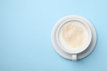 Aromatic coffee in cup on light blue background, top view. Space for text