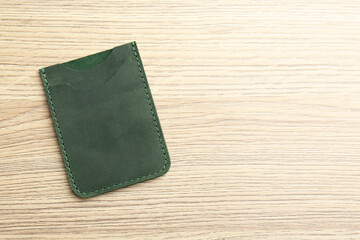 Leather business card holder on wooden table, top view. Space for text