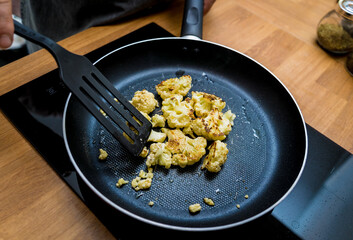 Chef at the kitchen preparing bean porridge with cauliflower and vegetables