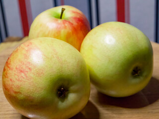 Fresh Apple Assortment. A selection of apples, some green and one red, on a wooden surface, ideal for health and nutrition content.