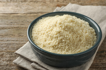 Fresh almond flour in bowl on wooden table, closeup